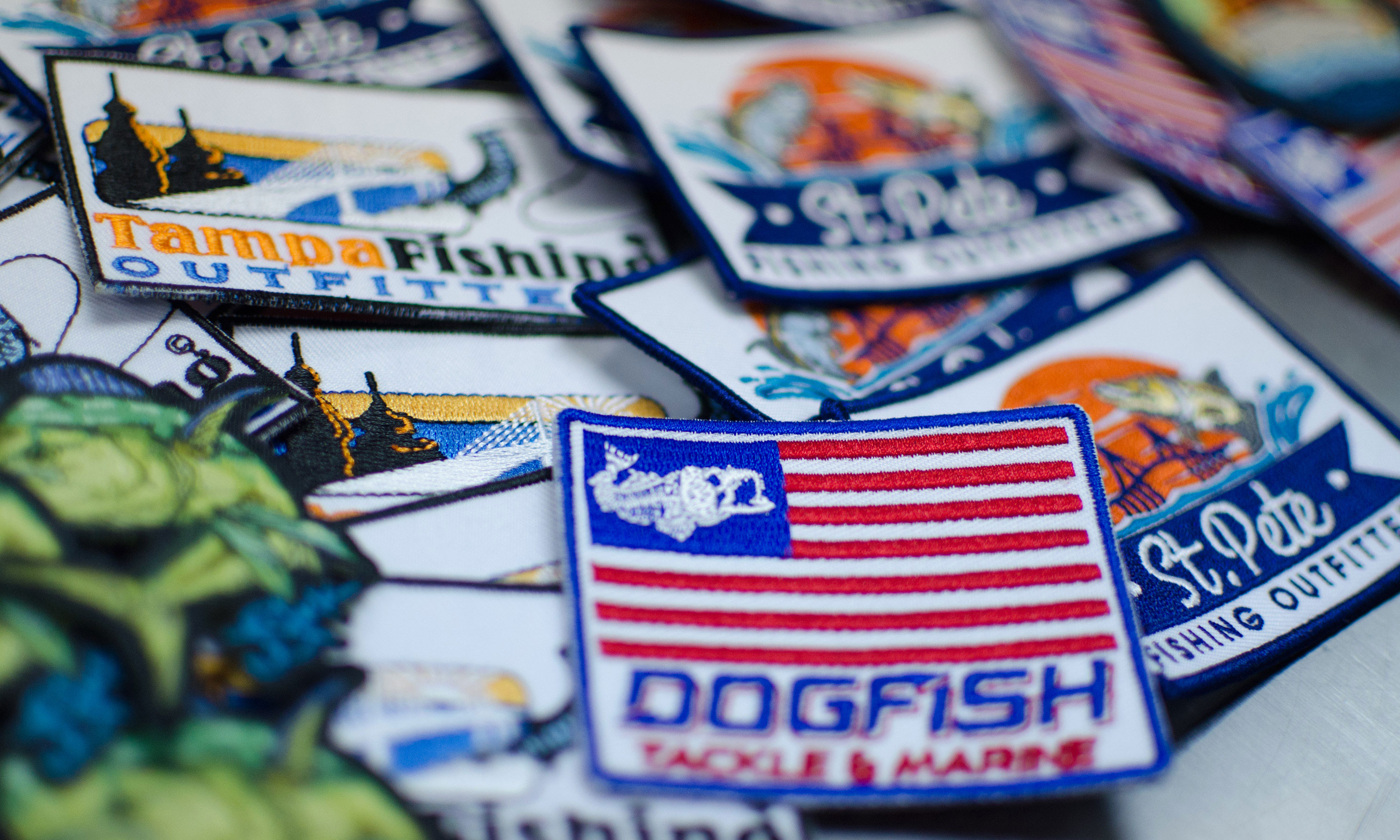 Closeup of various hat patches across table